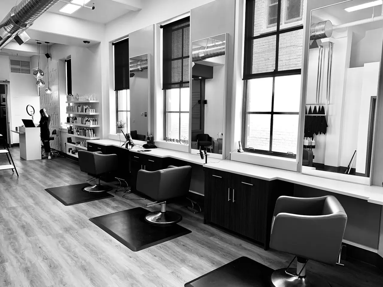 A calm, light-filled salon interior with styling stations and tall windows